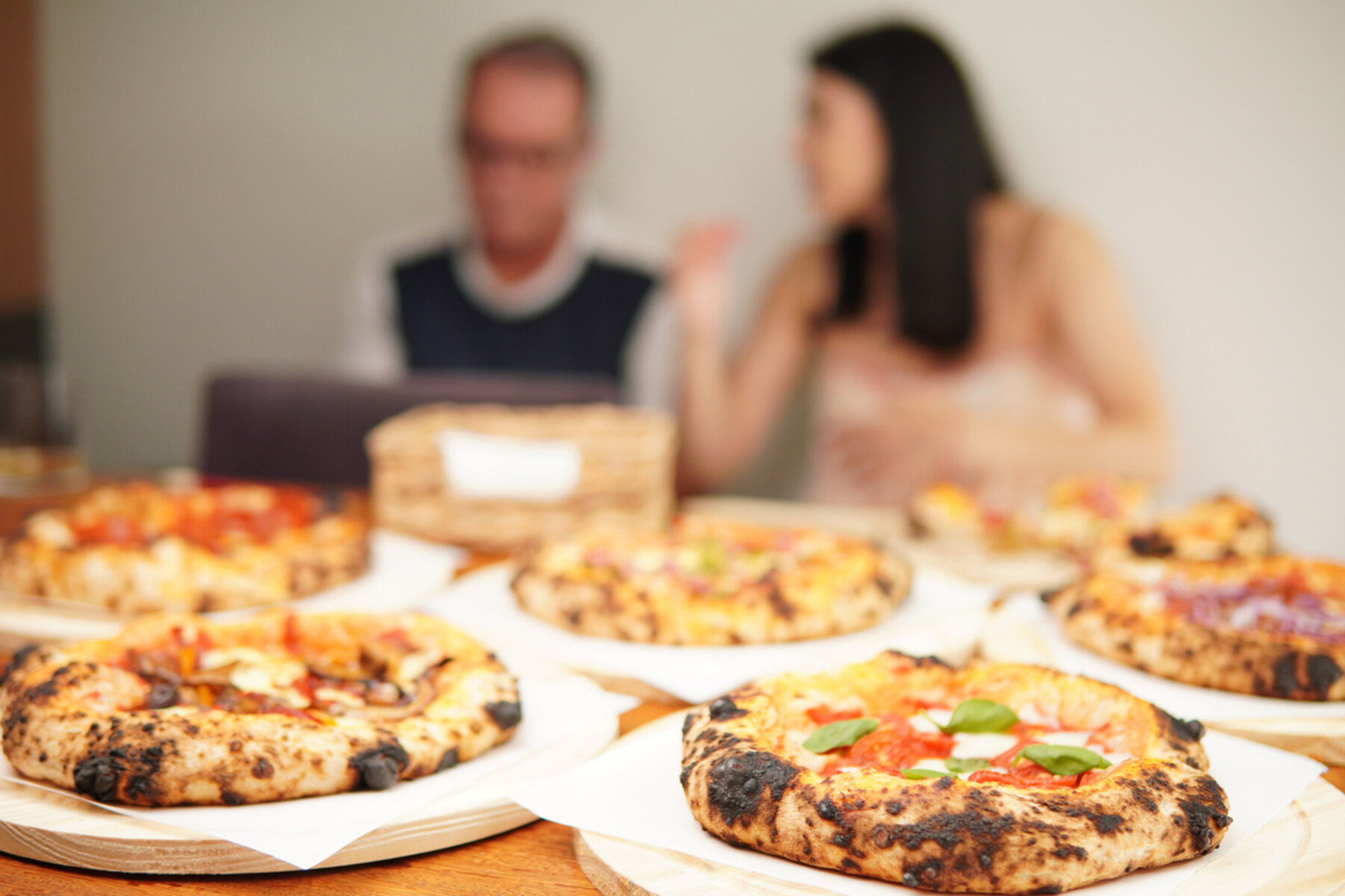 Mesa posta com pizzas artesanais da Trigô servidas durante um evento